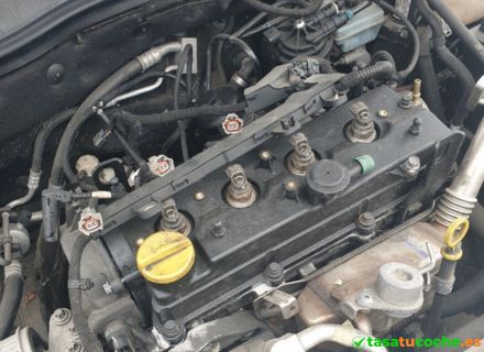 Detalle del motor de un coche averiado con componentes visibles